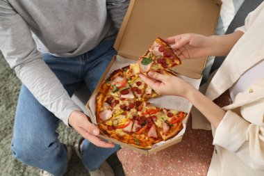 Evde lezzetli pizzaları olan genç bir çift, yakın plan.