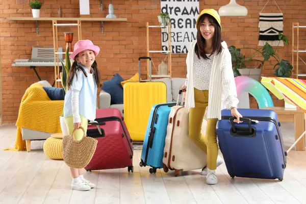 stock image Young Asian mother and her daughter with many suitcases walking at home. Travel concept