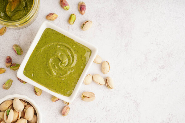 Вкусная фисташковая паста в миске на белом фоне