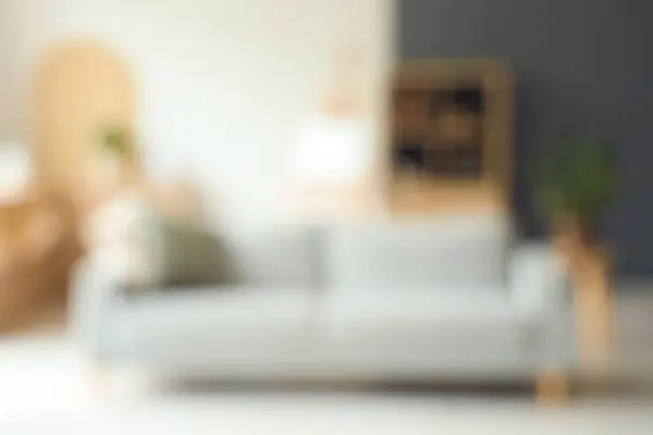 stock image Blurred view of modern living room with grey sofa