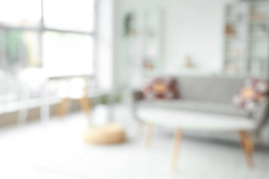 Gri kanepeli, masalı ve raf üniteli oturma odasının bulanık görüntüsü