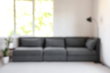 Siyah kanepe ve halı ile aydınlık oturma odasının bulanık görüntüsü