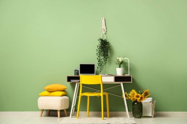 Çalışma odasının yanında vazo ve ayçiçekleri var.