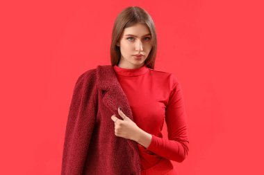 Pretty stylish young woman on red background
