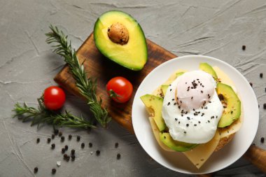 Gri arka planda lezzetli yumurta Benedict tabağı.