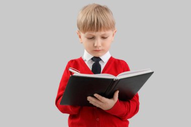 Gri arka planda not defterine komik bir iş adamı yazıyor.