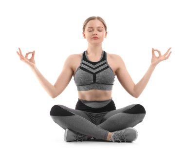 Sportif genç bir kadın beyaz arka plan üzerinde meditasyon yapıyor. Denge kavramı