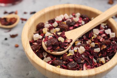 Gri grunge masasında kurutulmuş meyve çaylı kase ve kaşıklar, yakın plan.