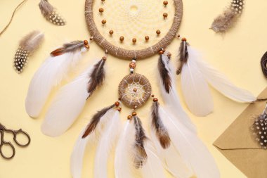 Sarı arka planda materyalleri olan rüya yakalayıcı, yakın plan