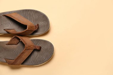 Bej arka planda kahverengi parmak arası terlikler