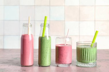 Gözlükler ve pembe masada renkli meyve püresi.