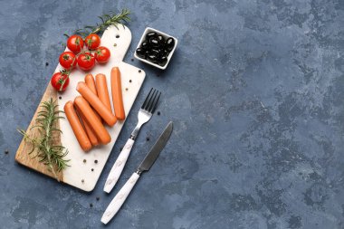 Mavi arka planda sosisli, domatesli ve zeytinli tahta