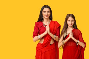 Anne ve kızı sari 'de sarı arka planda dua ediyorlar. Divaly kutlaması