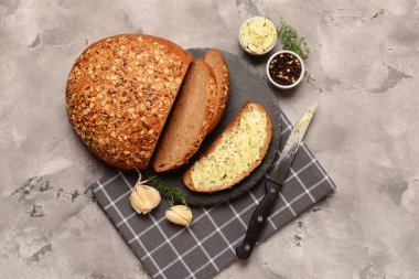 Taze tereyağlı ekmek dilimleri ve gri arka planda farklı baharatlar.