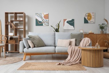 Kanepesi, sehpası ve duvarında resimleri olan şık bir oturma odası.