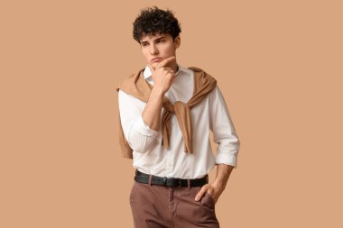 Kahverengi arka planda yakışıklı genç iş adamı