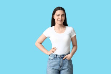 Mavi arka planda beyaz tişörtlü güzel bir bayan.