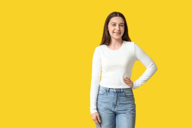 Sarı arka planda şık, beyaz, uzun kollu güzel bir kadın.