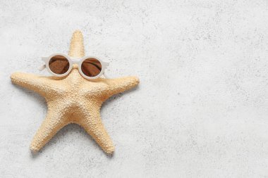 Beyaz grunge arka planda güneş gözlüklü denizyıldızı, yakın plan