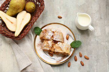 Lezzetli armutlu turta parçaları ve grunge grisi arka planda taze meyve sepeti.