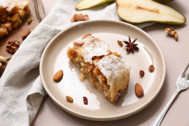 Lezzetli armutlu turta tabağı ve kahverengi arka planda taze meyve kesimi.