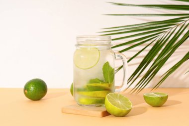 Limonlu ve tropikal yapraklı bir bardak taze mojito.