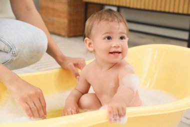 Annesiyle küvette küçük şirin bir bebek.