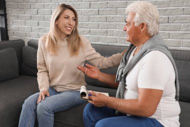 Ofisteki hipnoz sırasında koltukta oturan olgun bir kadın.