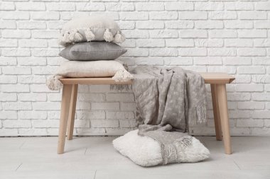 Beyaz tuğla duvarın yanında ekoseli kanepeler.