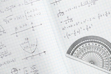 El yazısıyla yazılmış matematik formülleri ve arka plan olarak yarı dairesel açıölçer, yakın plan