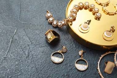 Siyah arka planda farklı mücevherleri olan dekoratif altın bir podyum. Üst görünüm