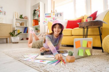 Ofiste yerde keçeli kalemlerle çalışan güzel bir grafik tasarımcısı.