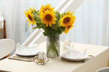 Servis masasında güzel ayçiçekleri olan vazolar