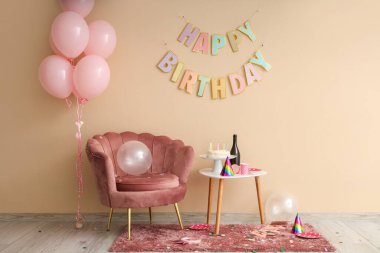 Doğum gününden sonra koltuk, masa ve balonlarla dolu dağınık bir oda.