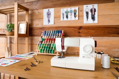 Modern atölyede dikiş makinesi ve iplik makarasıyla terzinin işyeri