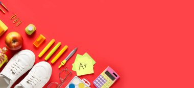 Kırmızı zemin üzerinde birçok okul malzemesi metin ve üst görünüm için boşluk ile