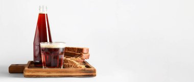 Açık arkaplanda cam ve bir şişe lezzetli kvass ve metin için yer