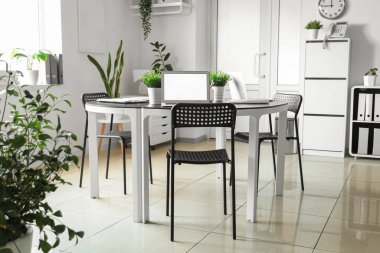 Masasında bitkiler ve dizüstü bilgisayarlar olan modern ofis.