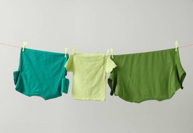 Gri arkaplanda asılı temiz tişörtler