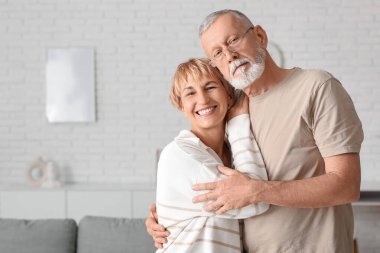 Evde kucaklaşan olgun bir çift.