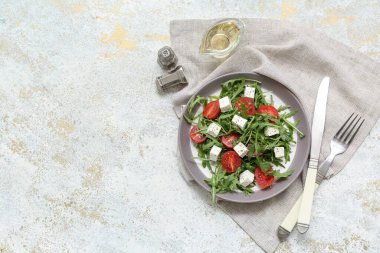 Hafif grunge arka planda sağlıklı sebze salatası, peçete ve çatal bıçak takımı.