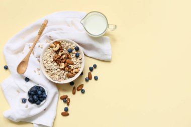 Peçete, fındık, çiğ yulaf ezmeli kase ve renkli böğürtlen.