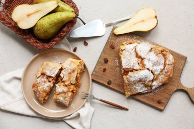 Ahşap ahşap tahta ve tabakta gri arka planda lezzetli armutlu turta parçaları var.