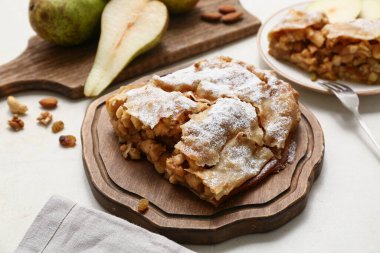 Bej arka planda lezzetli armut turtası olan ahşap tahta.