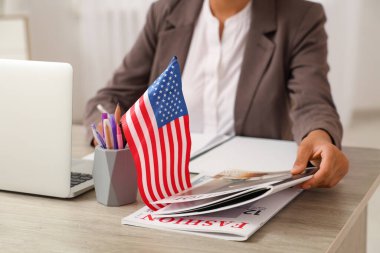 Amerikan bayrağı ve dergileriyle genç ve güzel Afro-Amerikan iş kadını.