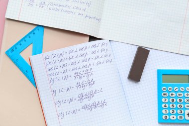 Matematik formüllü metin kitapları ve renk arkaplanı kırtasiyesi, yakın plan