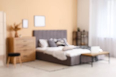 Rahat bir yatak, raflar, çekmeceler ve yatak odasının içindeki bank. Bulanık görünüm