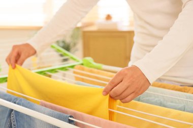 Çamaşır odasında temiz giysileri kurutucuya asan adam, yakın plan.