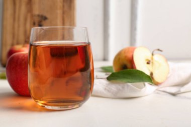 Beyaz arka planda bir bardak taze elma suyu