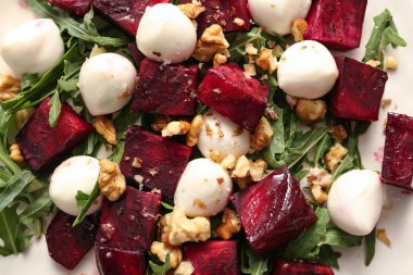 Beyaz arka planda pancar, ceviz ve mozzarella peynirli taze salata.